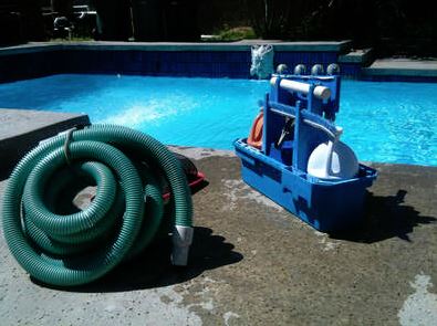 Picture of a green pool cleaning hose and a pool cleaning carrier with pool cleaning supplies in it