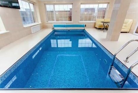 Picture of a clean blue nice lap pool indoors with a ladder