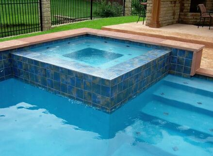 Picture of a nicely tiled blue hot tub in the corner of a pool in Little Rock Arkansas