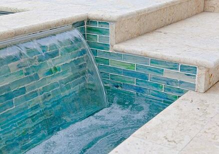 Picture of a green and white tiled pool waterfall on the side of a pool outside of Bryant Arkansas
